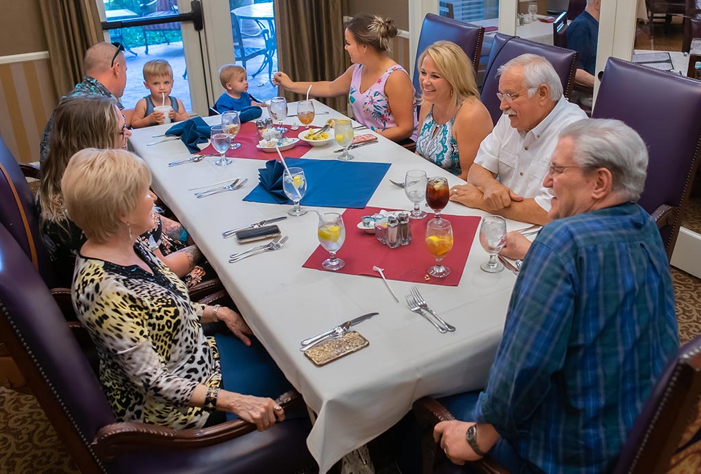 Seniors and family members enjoying a meal together in the dining room at a Franklin Park Senior Living community.