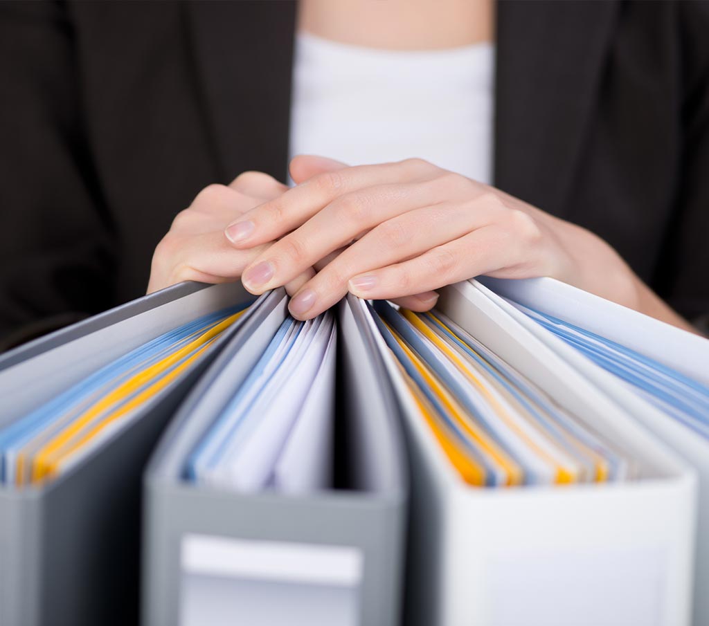 Close-up of a professional holding documents as part of Franklin Park Senior Living office support services.