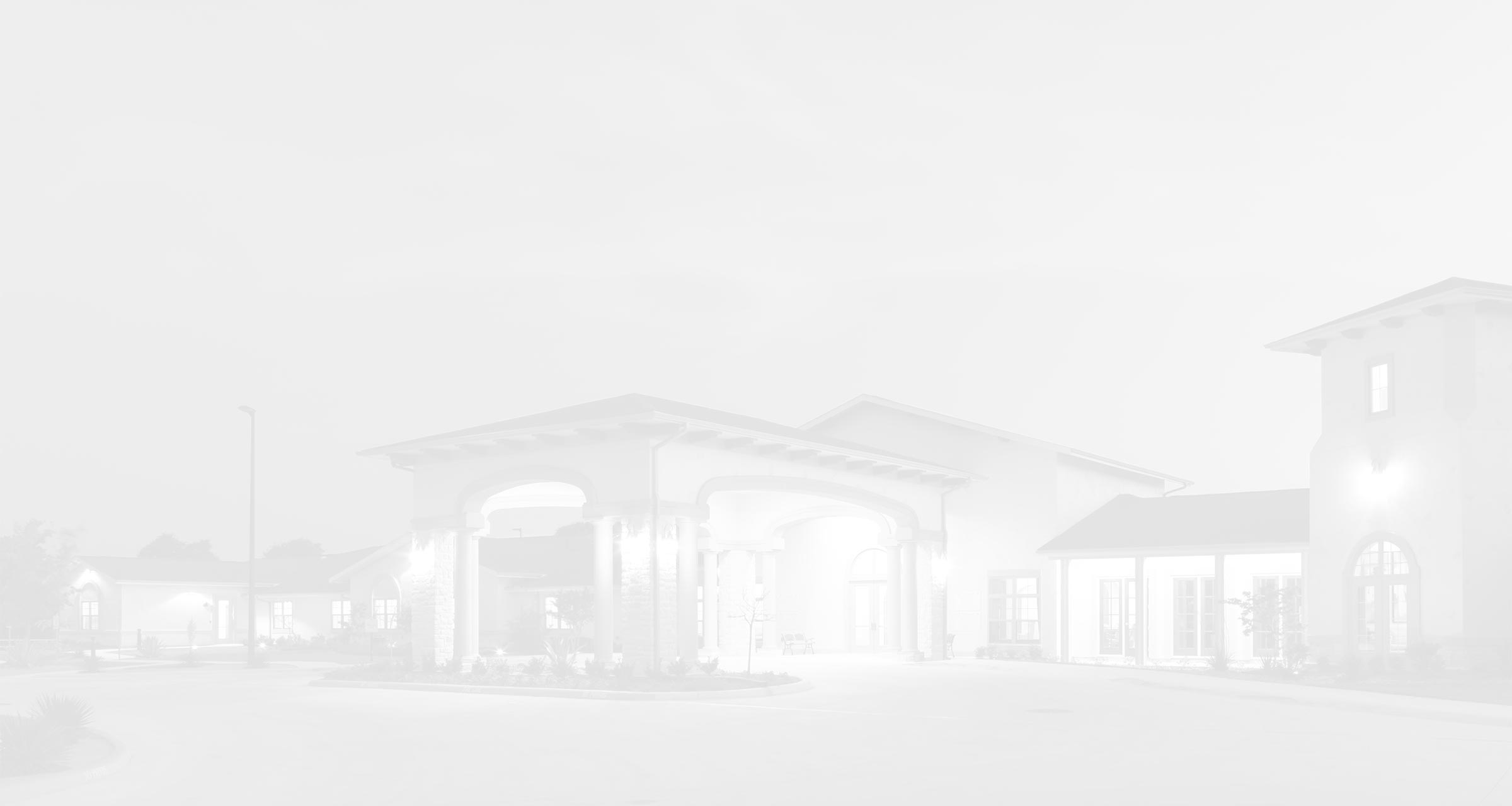 Exterior of a Franklin Park Senior Living community featuring a covered entrance, arched architecture, and a circular driveway.