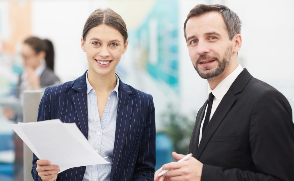 Two business professionals holding documents and representing Franklin Park Senior Living's management services.